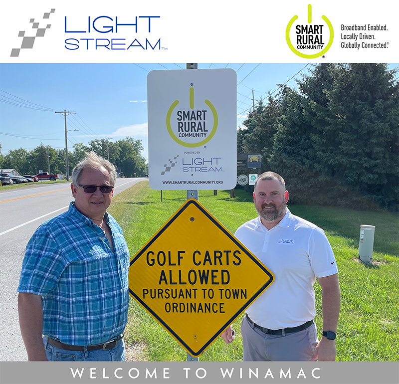 Smart Rural community members next to a "Golf Carts Allowed Pursuant to Town Ordinance" signs.